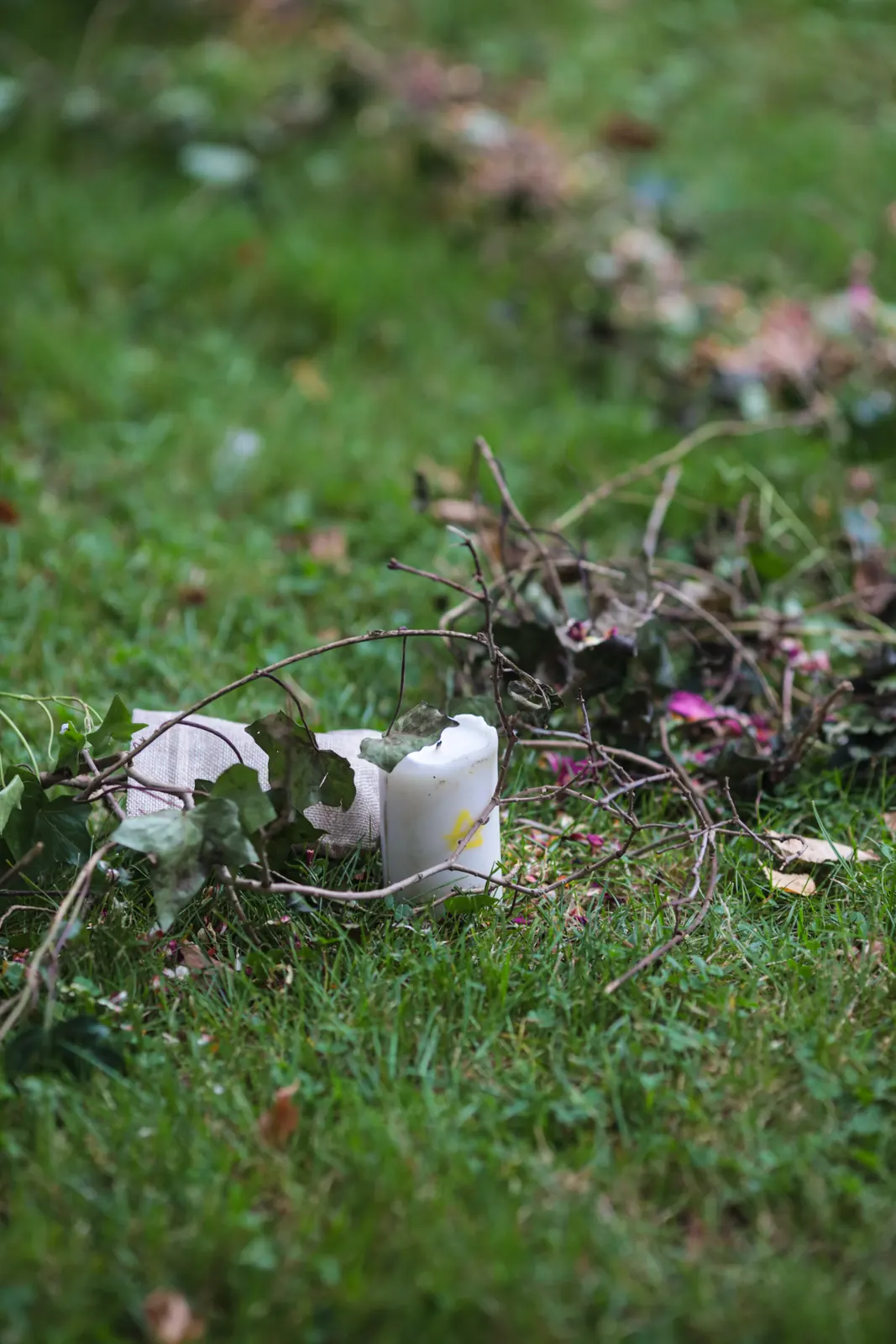 Bougie et fleurs posées dans l'herbe pour tracer le cercle d'une cérémonie druidique