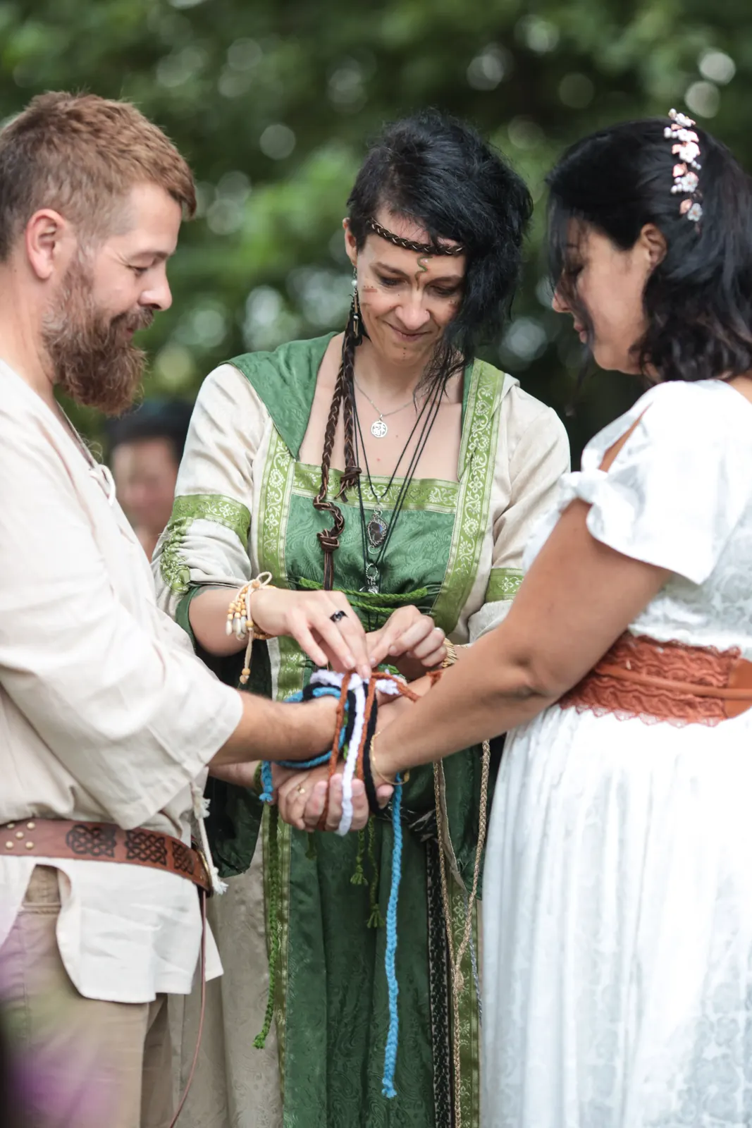 Handfasting : l'officiante noue les rubans autour des mains des mariés lors d'une cérémonie celtique