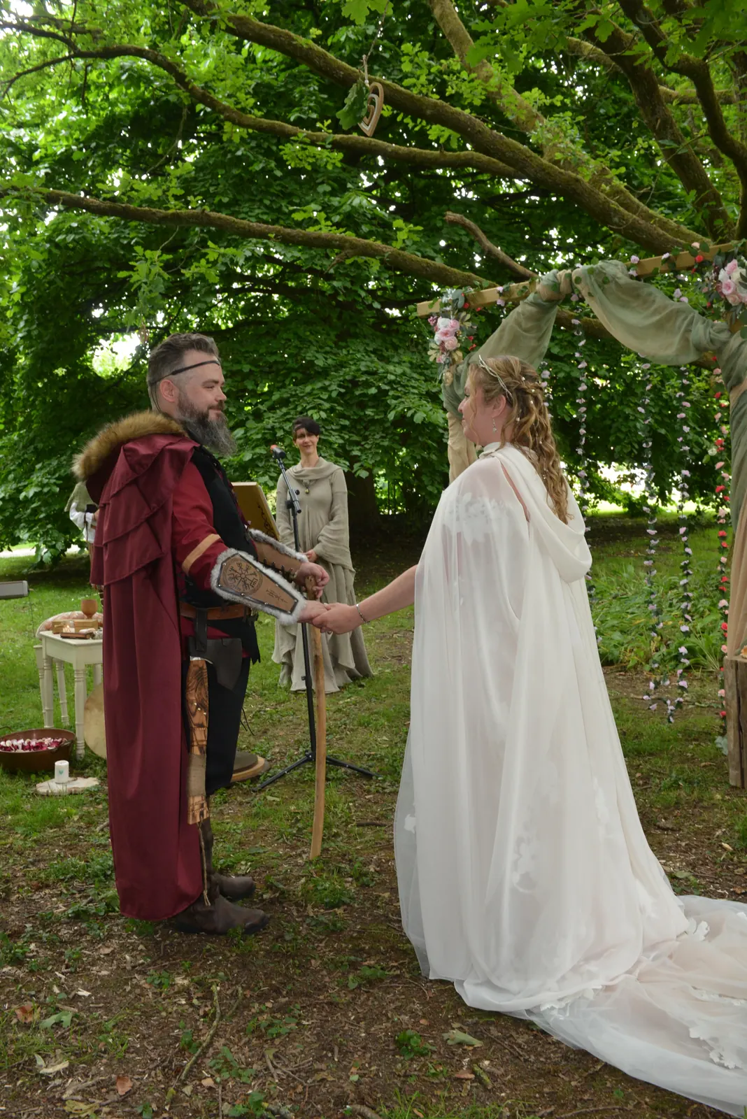 Mariés en tenue d'inspiration nordique sous un grand arbre lors d'une cérémonie viking